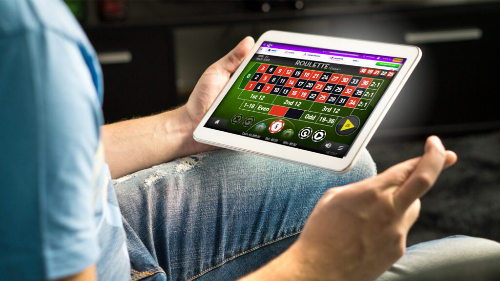 Hombre usando una tablet para acceder a una plataforma de juegos de la ruleta online.